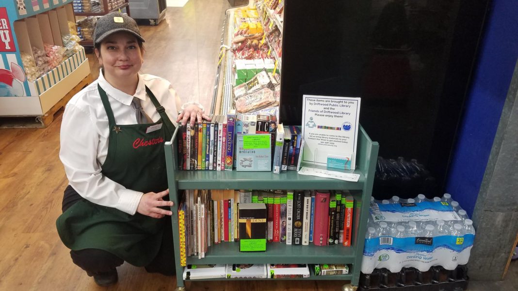 Chester's Thriftway Supervisor Elizabeth Davis poses with a "free library"